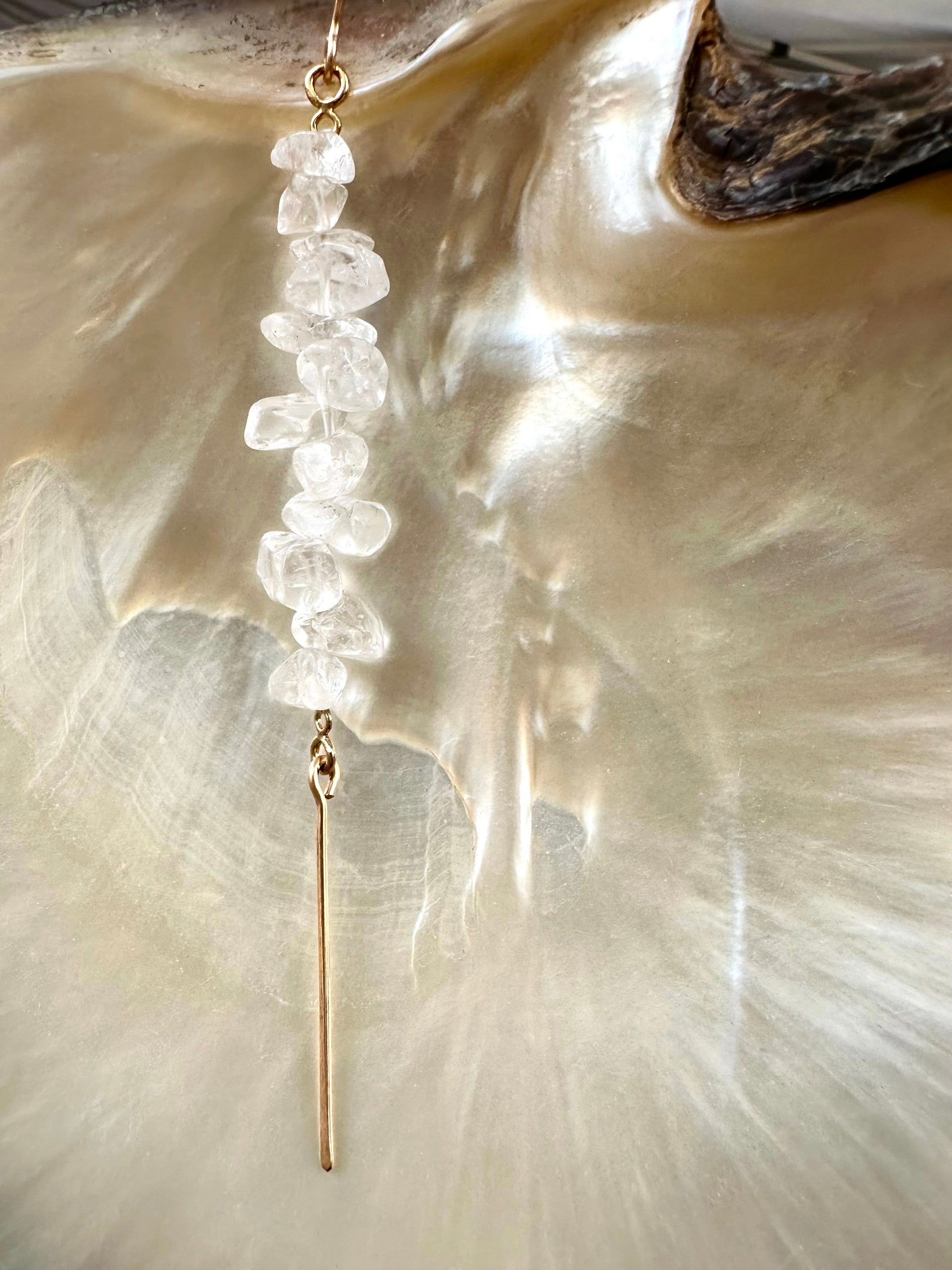 Akari drop earrings, quartz earrings, earrings in gold on shell close-up with drop sparkling