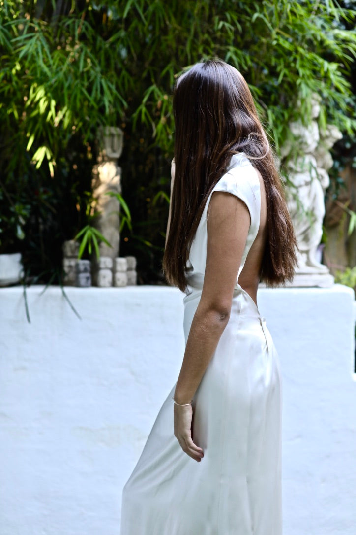Evelyn silk dress, high neckline backless dress white silk, dress side view on model hair down greenery background